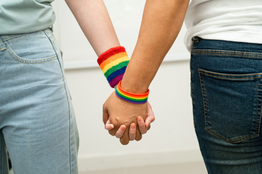 A imagem atual não possui texto alternativo. O nome do arquivo é: asian-lgbt-couple-woman-holding-hand-wearing-rainbow-wristband-scaled.jpg