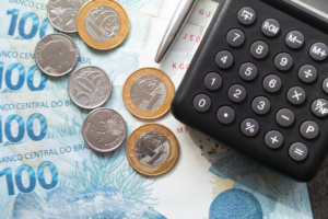 A imagem atual não possui texto alternativo. O nome do arquivo é: finance-concept-one-hundred-reais-bills-coins-with-calculator-pen-brazilian-money-scaled-e1777922094.jpeg